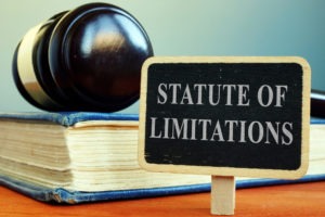 A small sign that reads “statute of limitations” is in front of a gavel resting on top of a book.