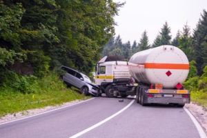 A fuel truck crashes into a passenger vehicle head-on.