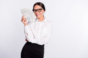 happy woman holding wad of hundreds