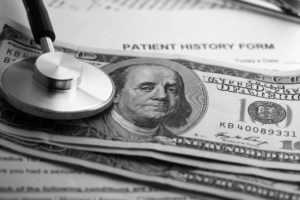 patient history form with stethoscope and money