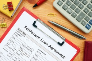 A settlement loan document attached to a red clipboard