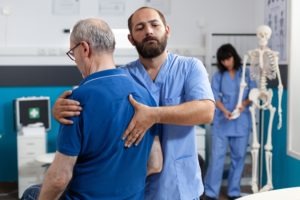 orthopedic nurse helping a patient with back issues