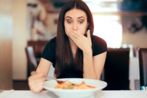 woman feeling sick while eating