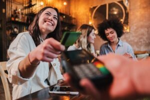 woman happily paying for dinner