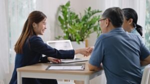 loan agent shaking hands with happy couple